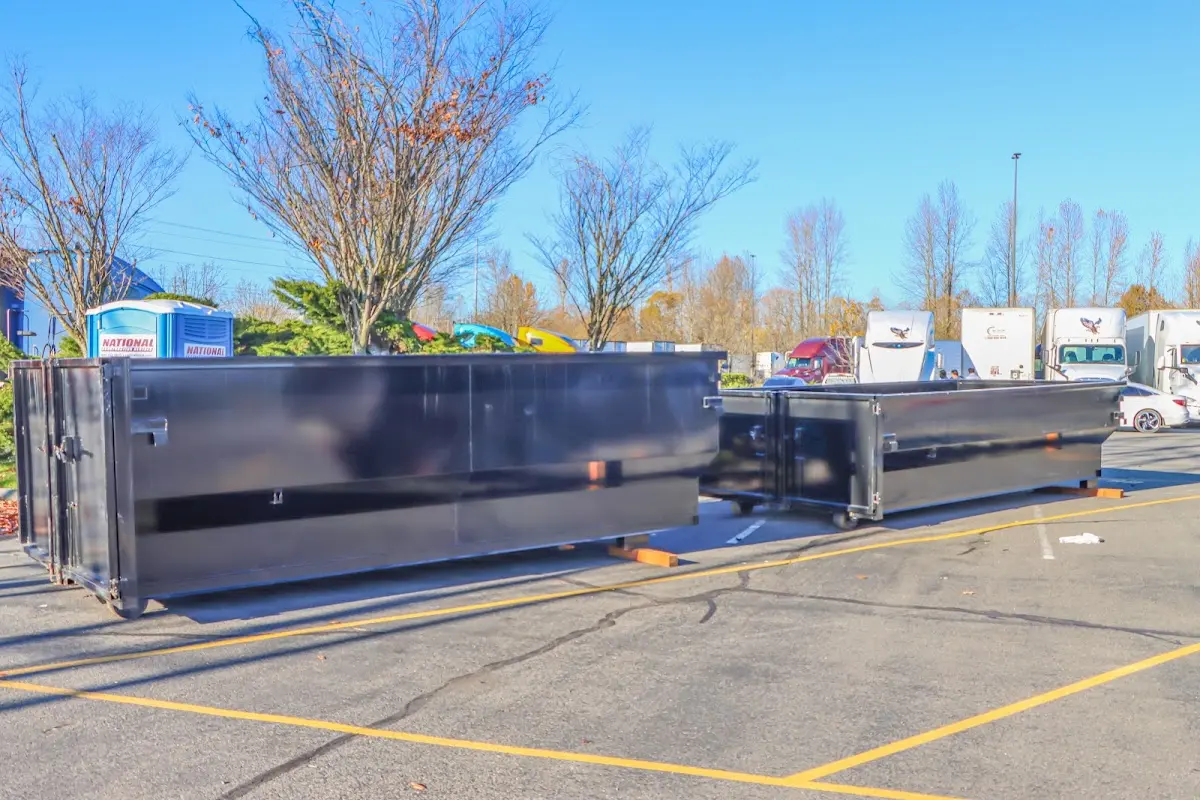 Professional dumpster rental service with roll-off container on residential driveway in Big Flats